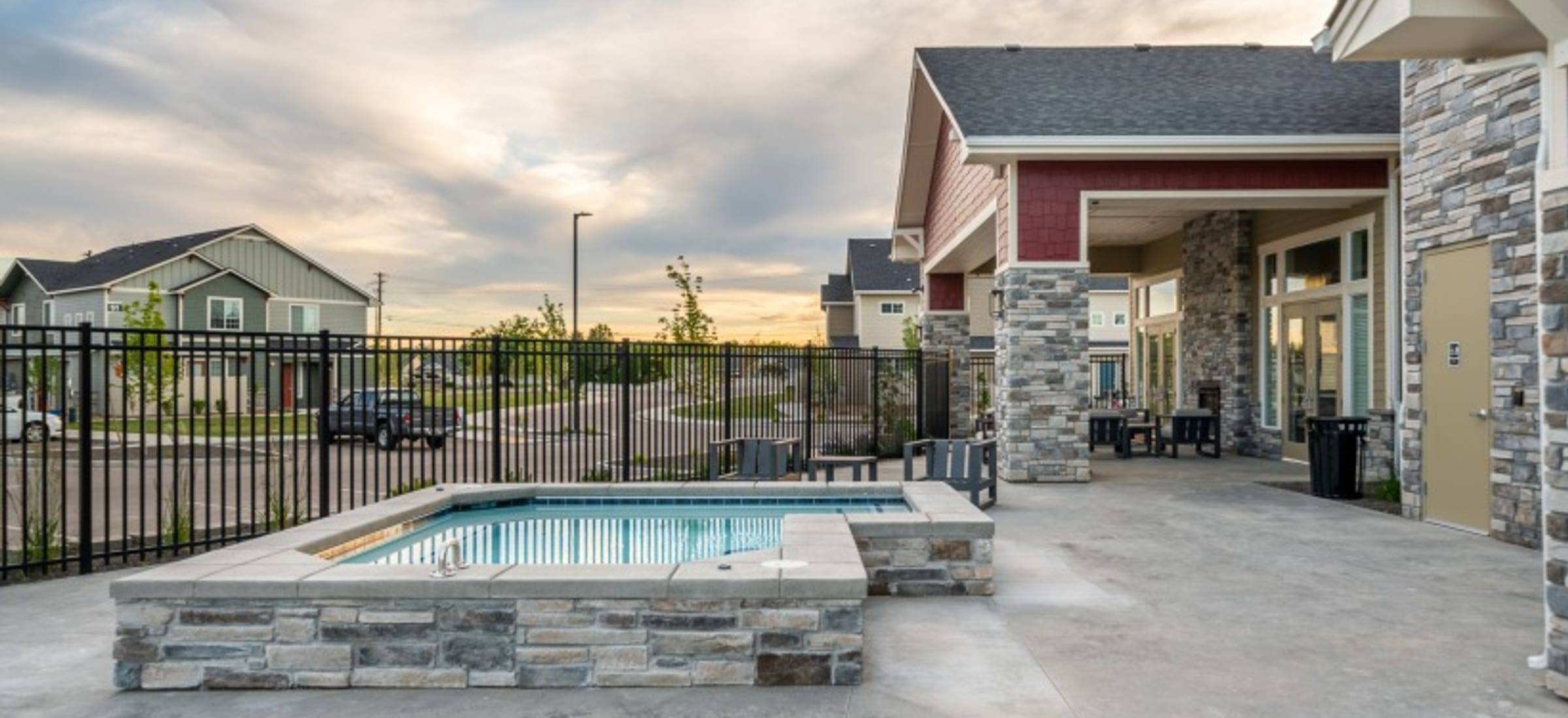 The spa and resort-style pool beside the clubhouse at sunset, with townhomes beyond