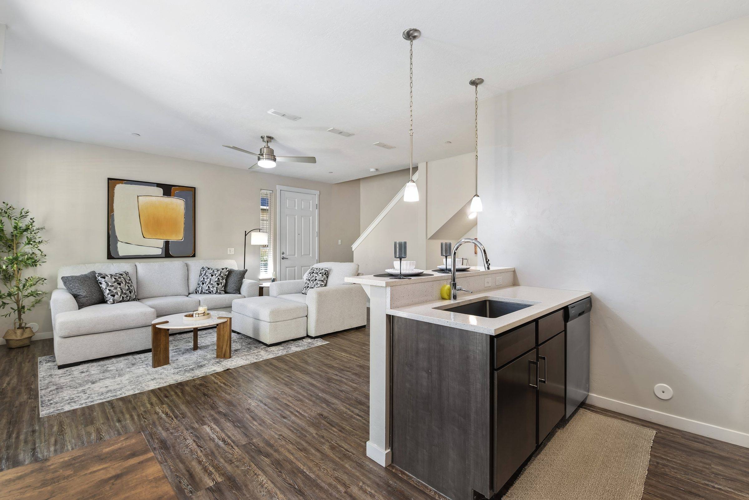 Open-concept living room and kitchen with natural light in a model townhome