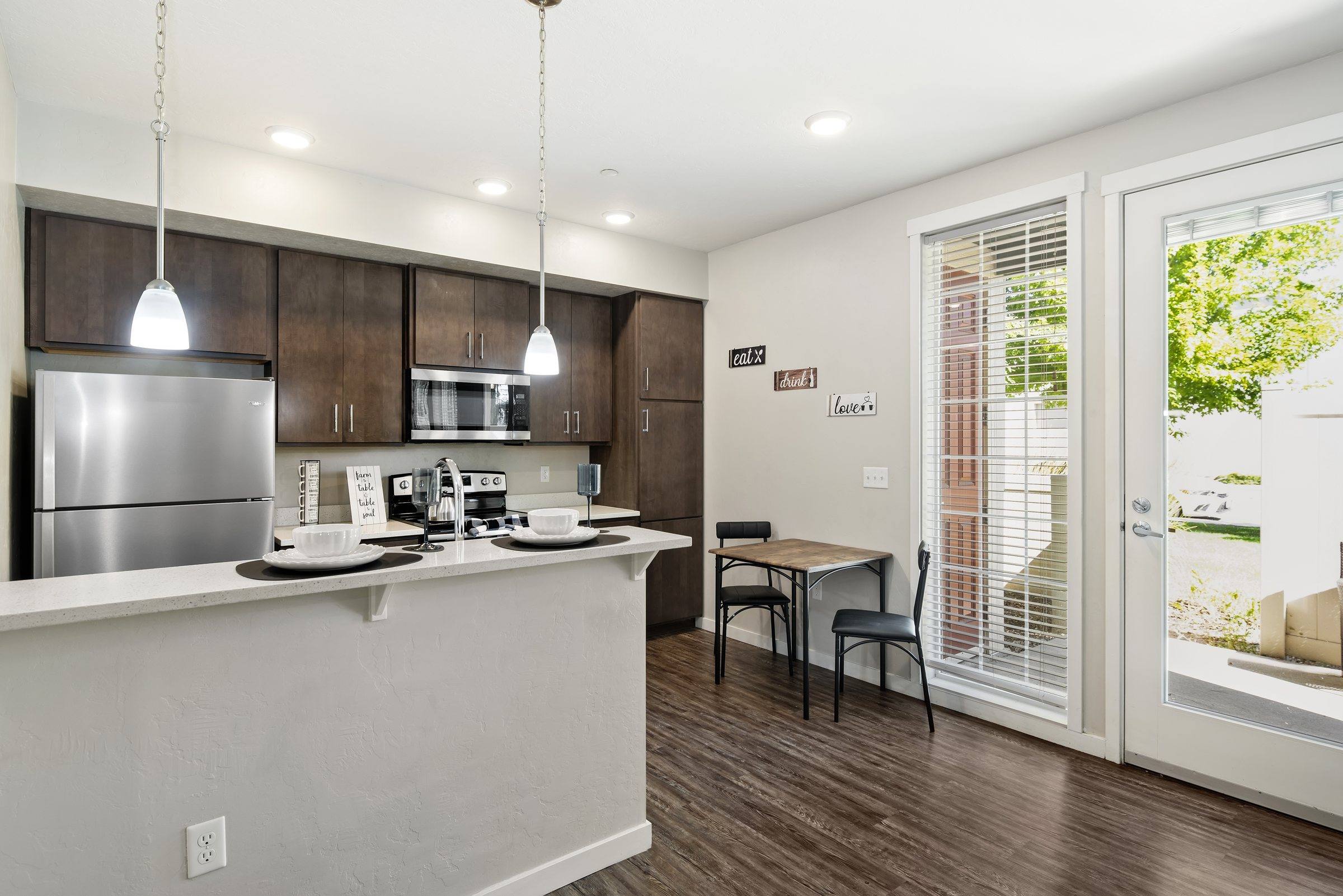 Kitchen with an island and stainless appliances open to the dining area in a model townhome